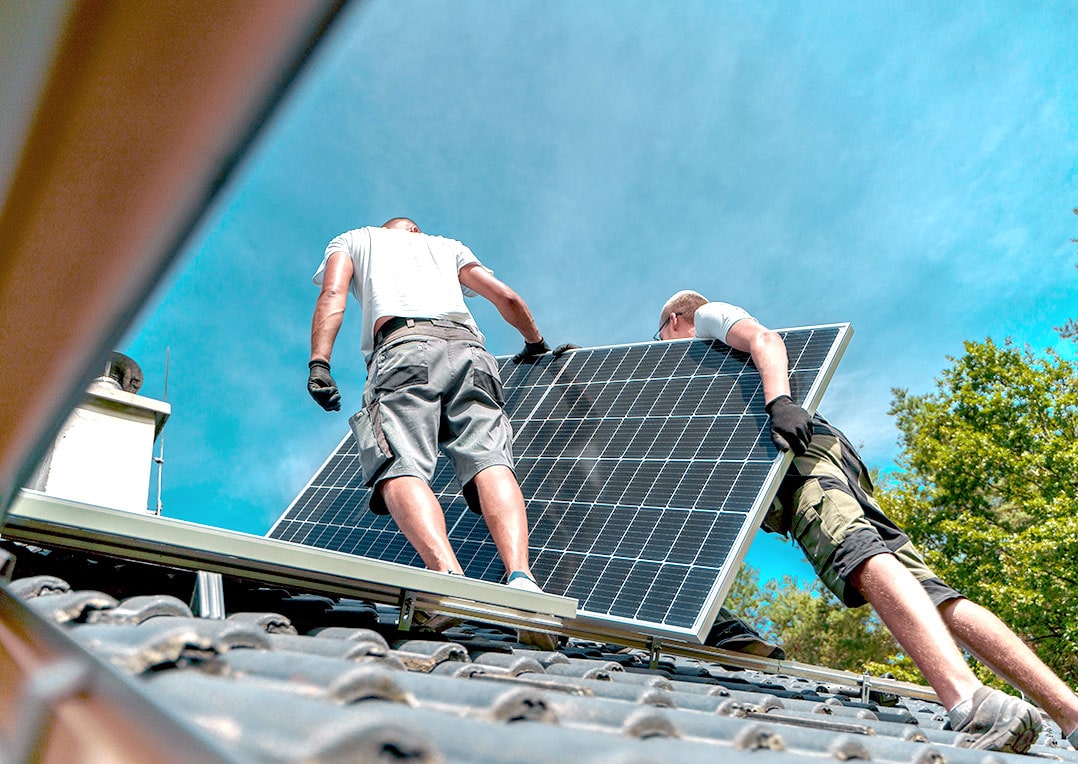 Regionaler Arbeiter eines Fachbetriebes installieren Photovoltaik-Solarmodule auf dem Dach, alternative Energie, Ressourcen sparen